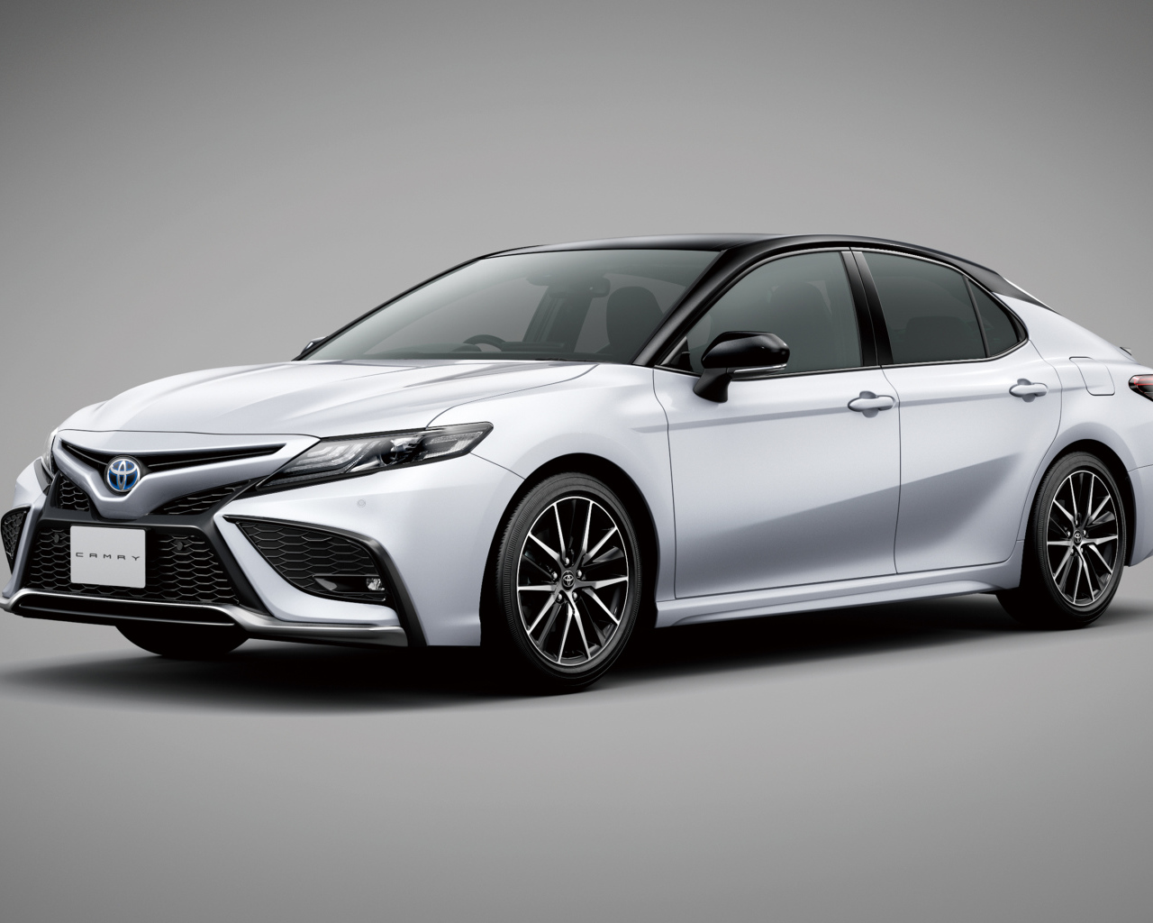 Автомобиль Toyota Camry 2021 года на сером фоне