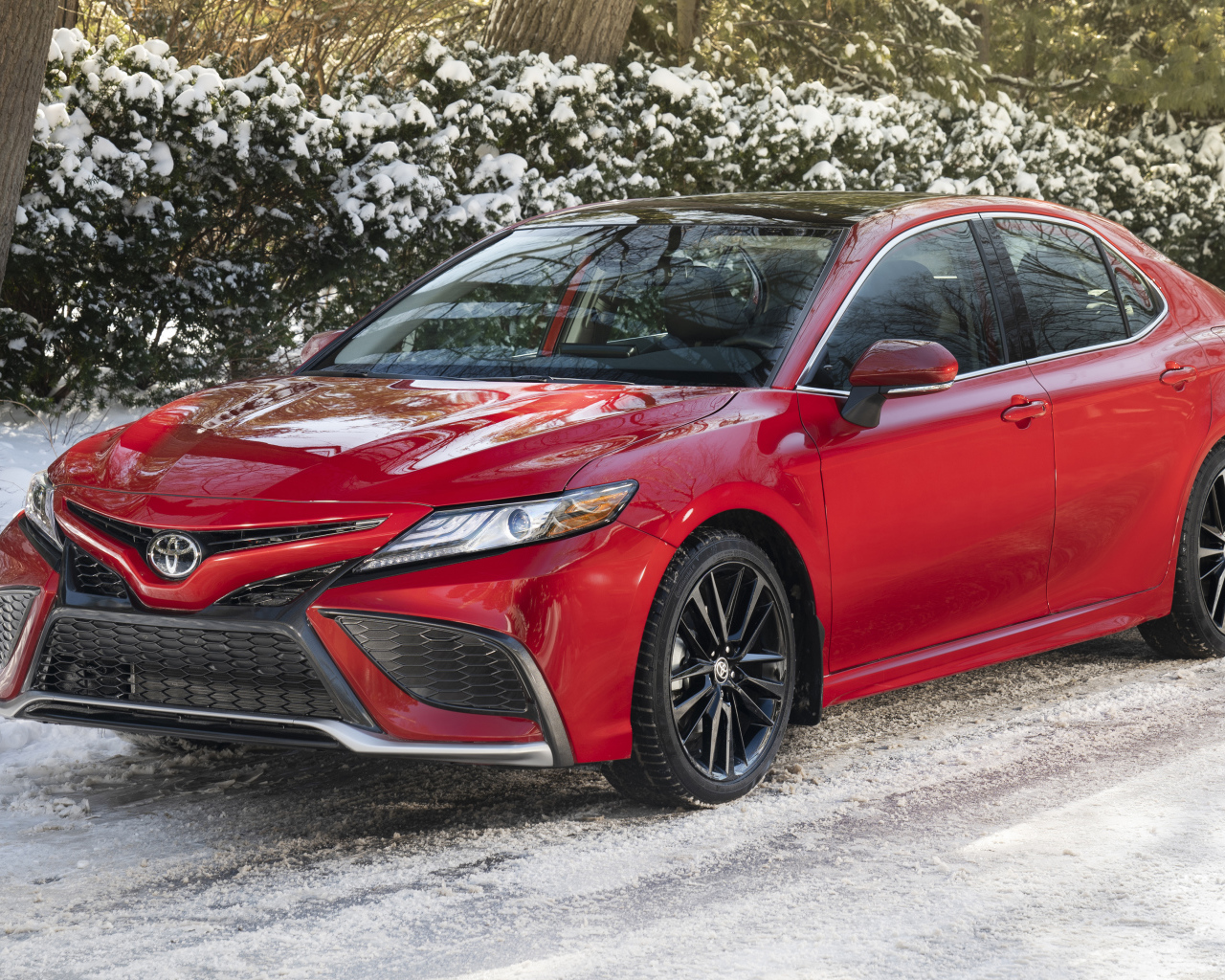 Красный автомобиль  Toyota Camry XSE AWD, 2021 года зимой