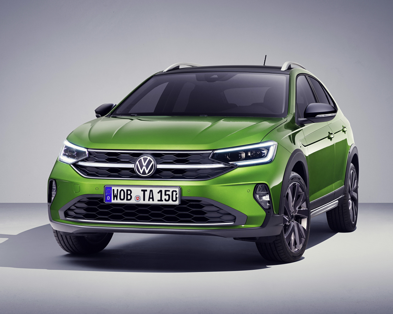 Зеленый стильный Volkswagen Taigo 2021 года на сером фоне