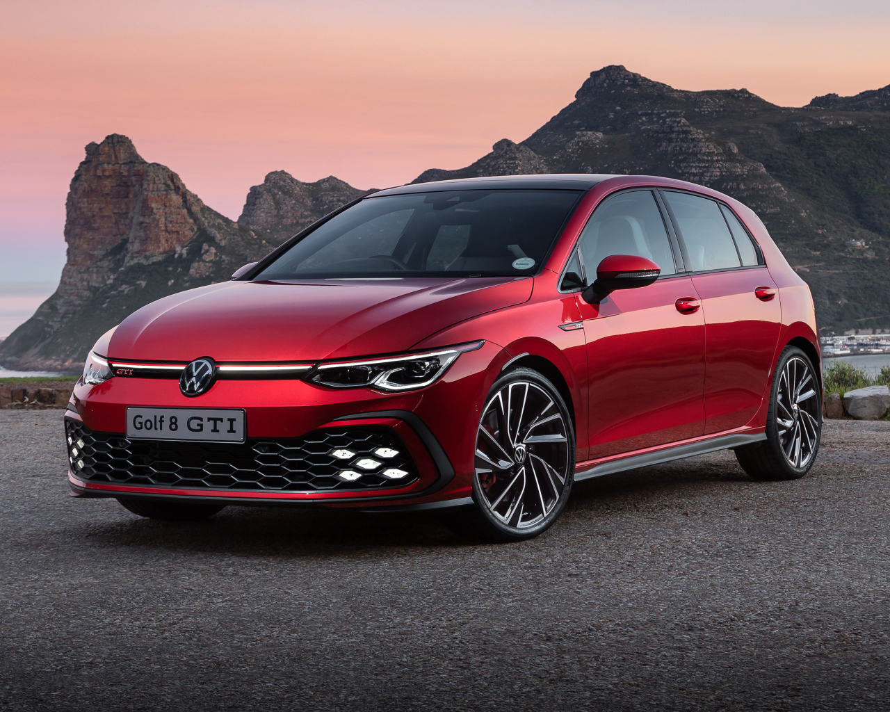 Красный Volkswagen Golf GTI 2021 года на фоне гор