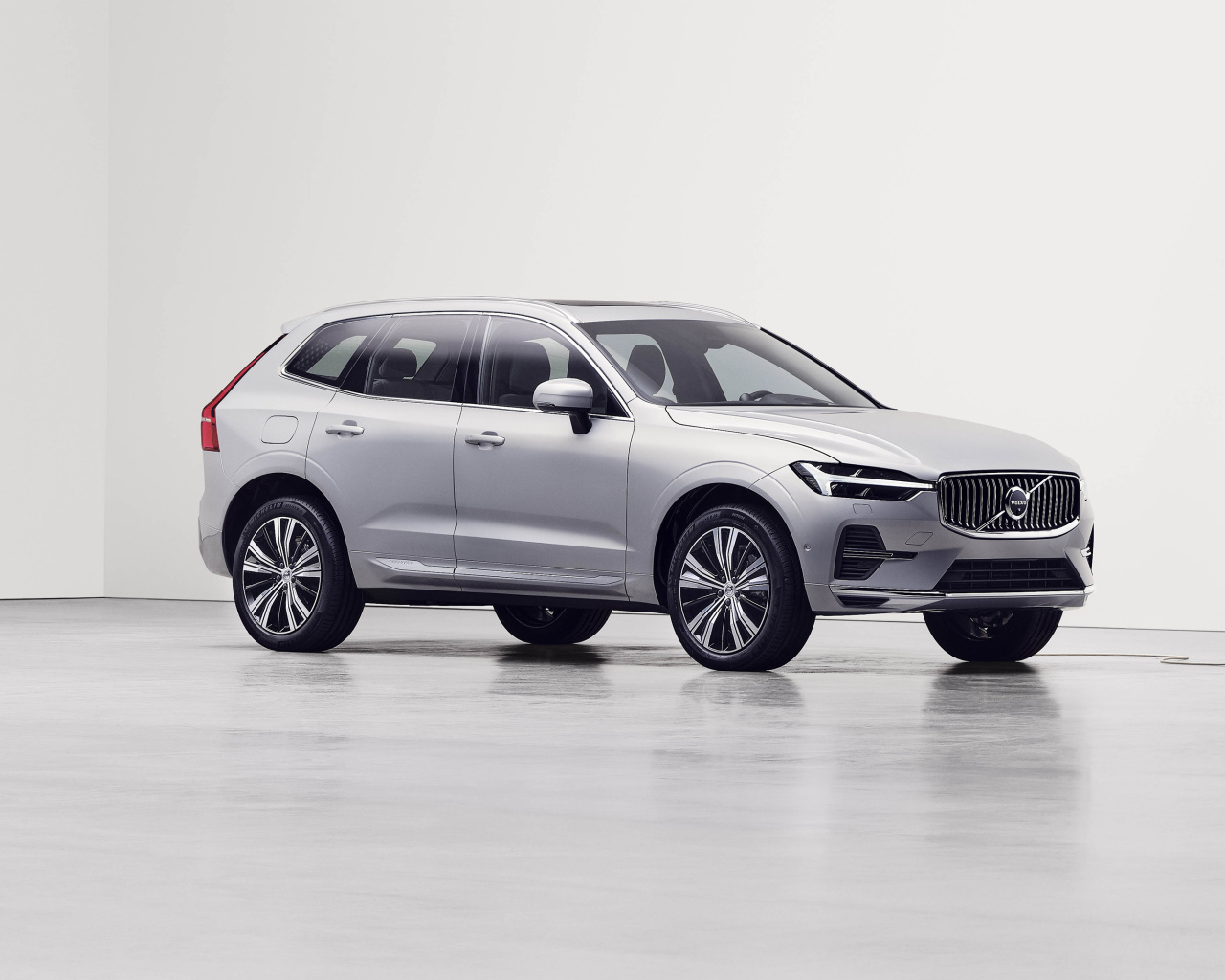 Серебристый электромобиль Volvo XC60 T8 Recharge AWD, 2021 года на заправке