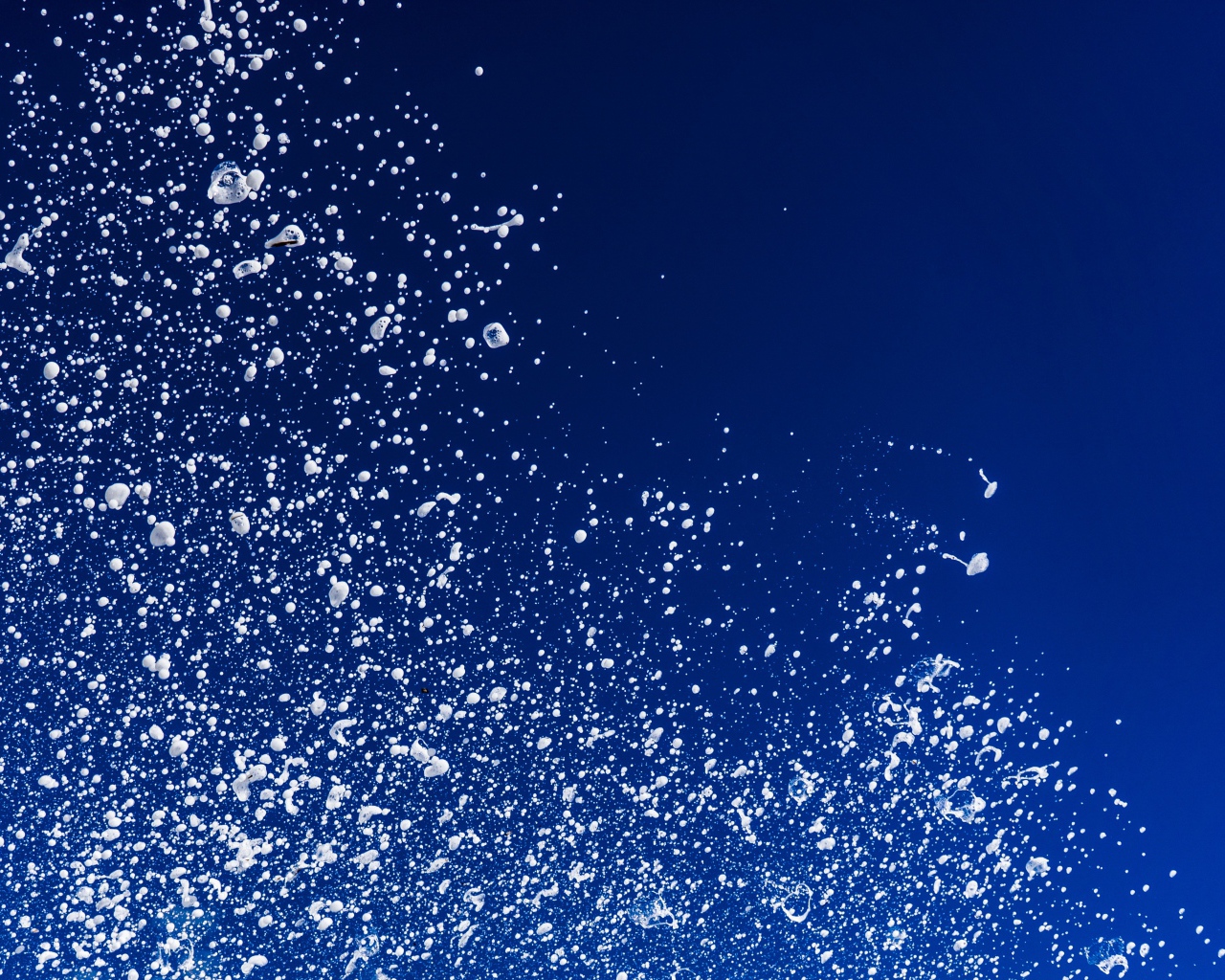 Белые брызги воды на синем фоне 