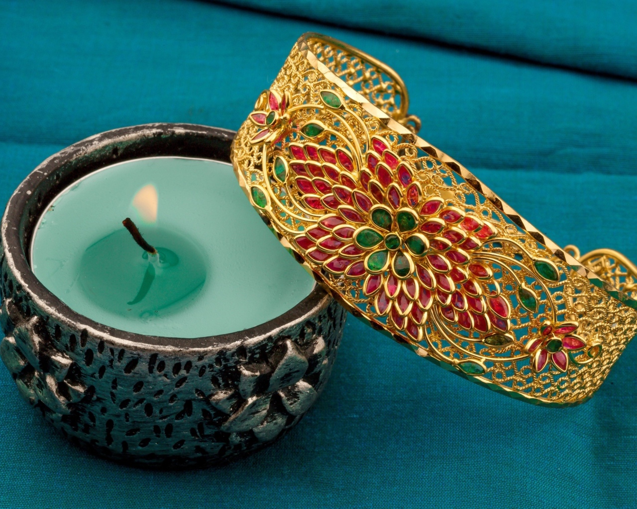 Красивый браслет со свечой на синем покрывале 