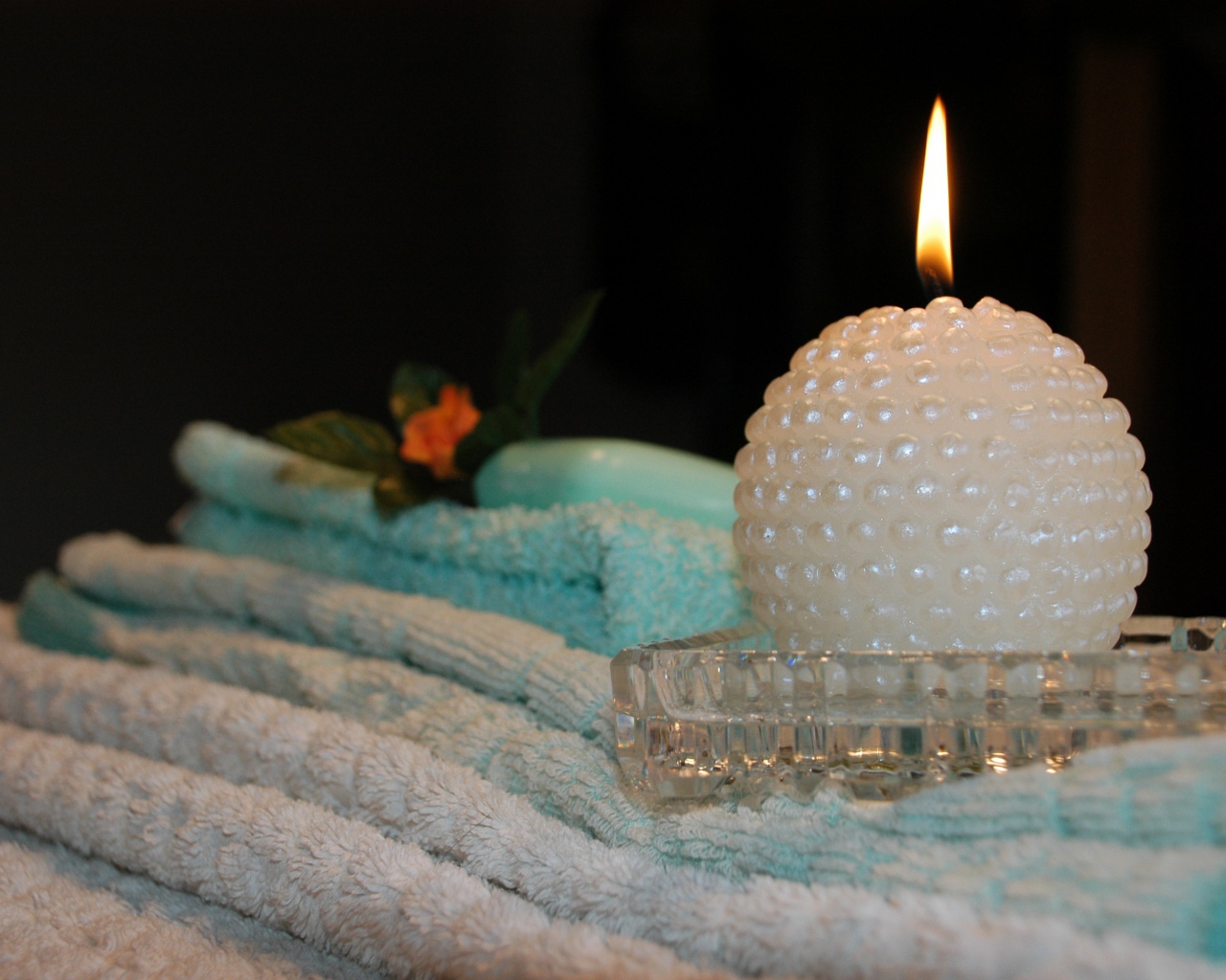 Красивая зажженная свеча с полотенцами