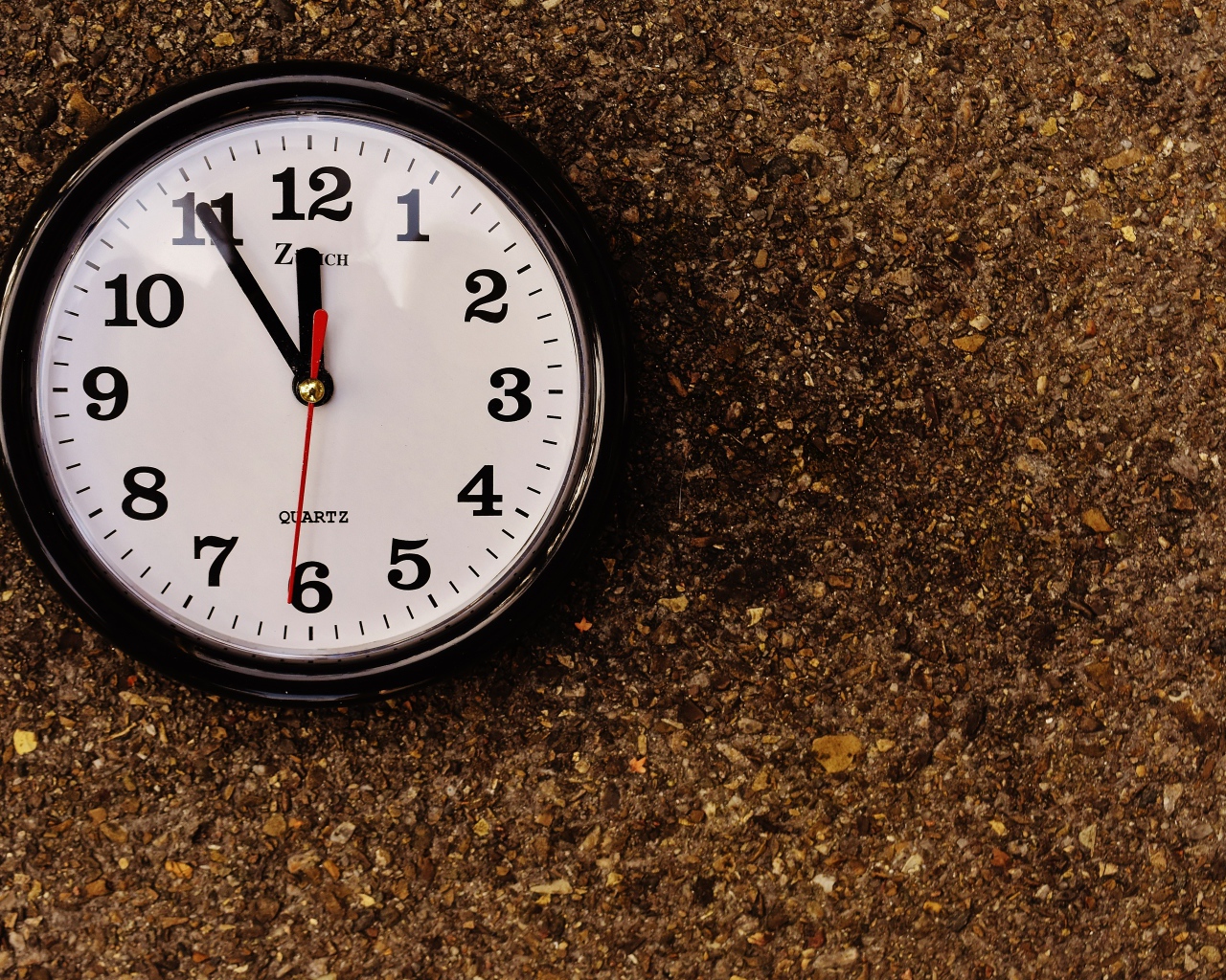 Большие черные часы висят на стене 