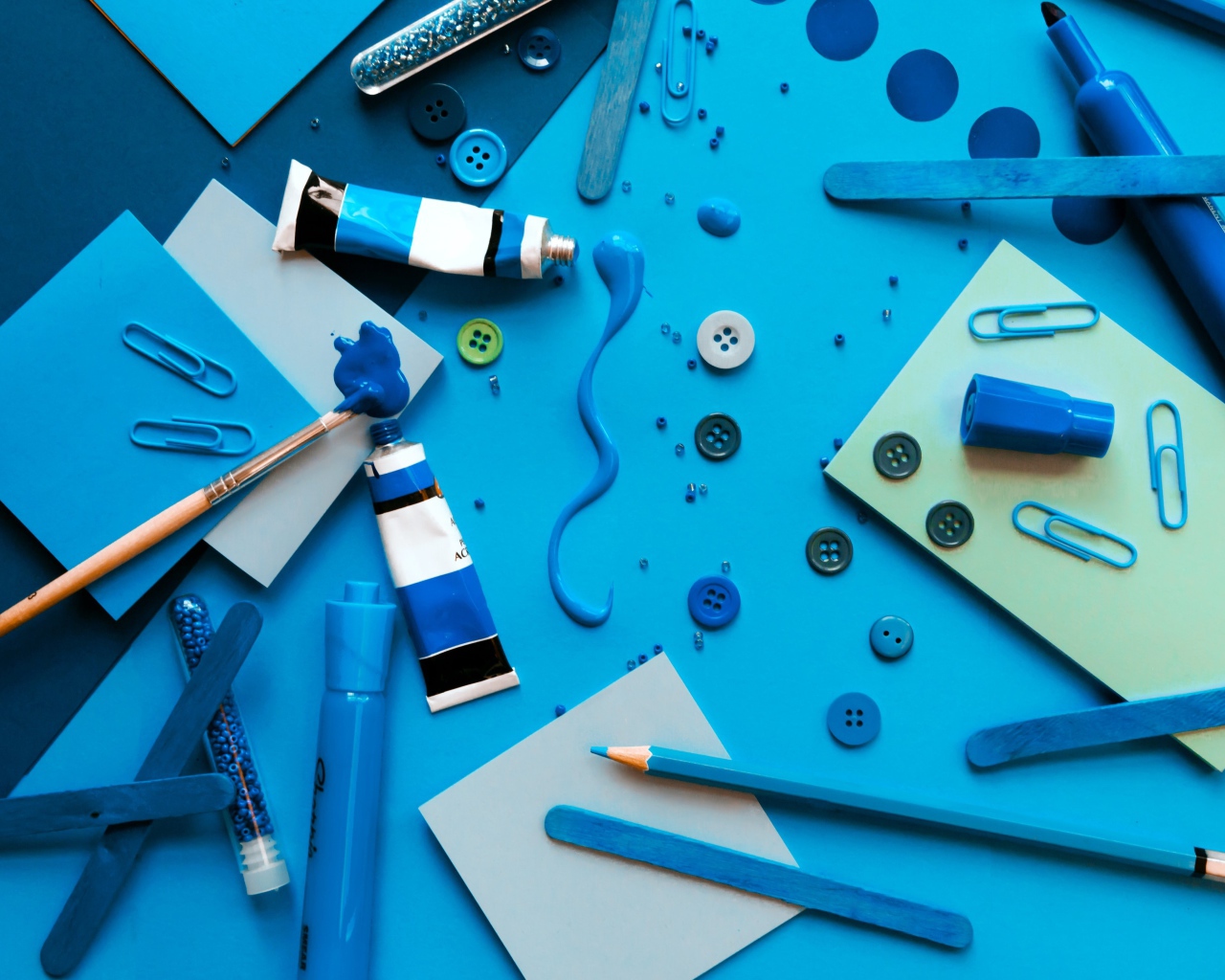 Синие канцелярские предметы, бумага и краски на столе 