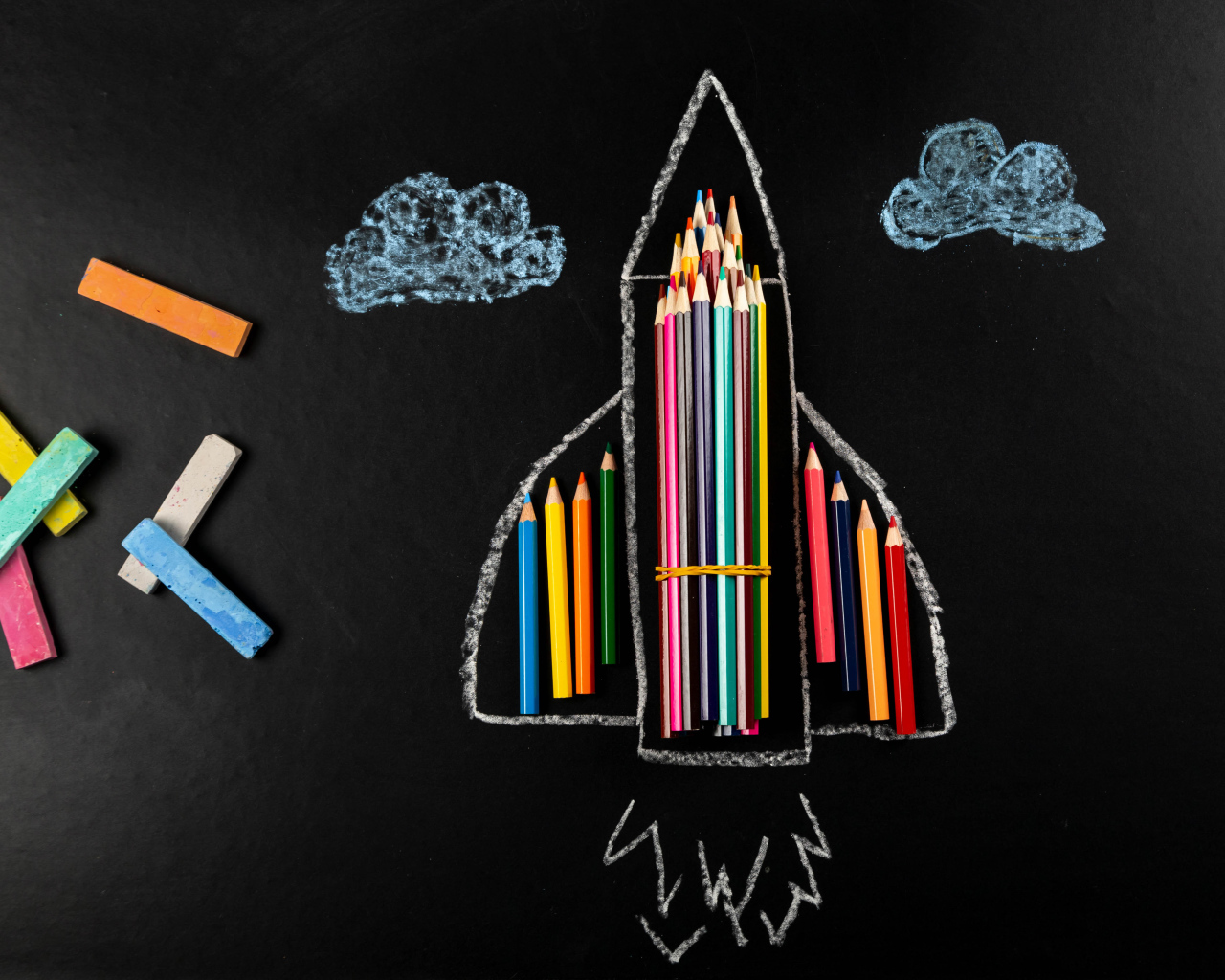 Нарисованная ракета с мелом и карандашами 