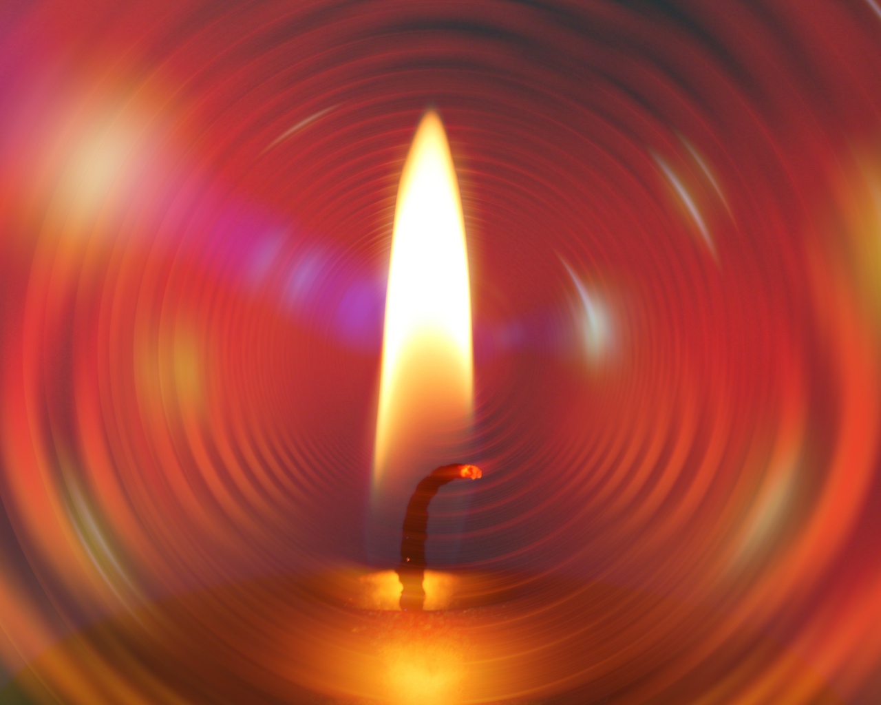 Огонь свечи на фоне красного круга 