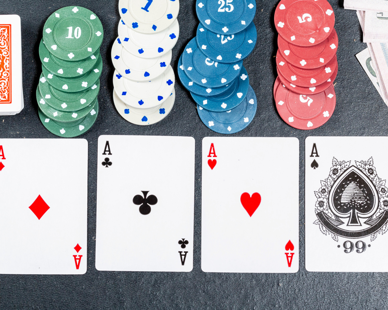 Четыре туза с фишками на сером столе