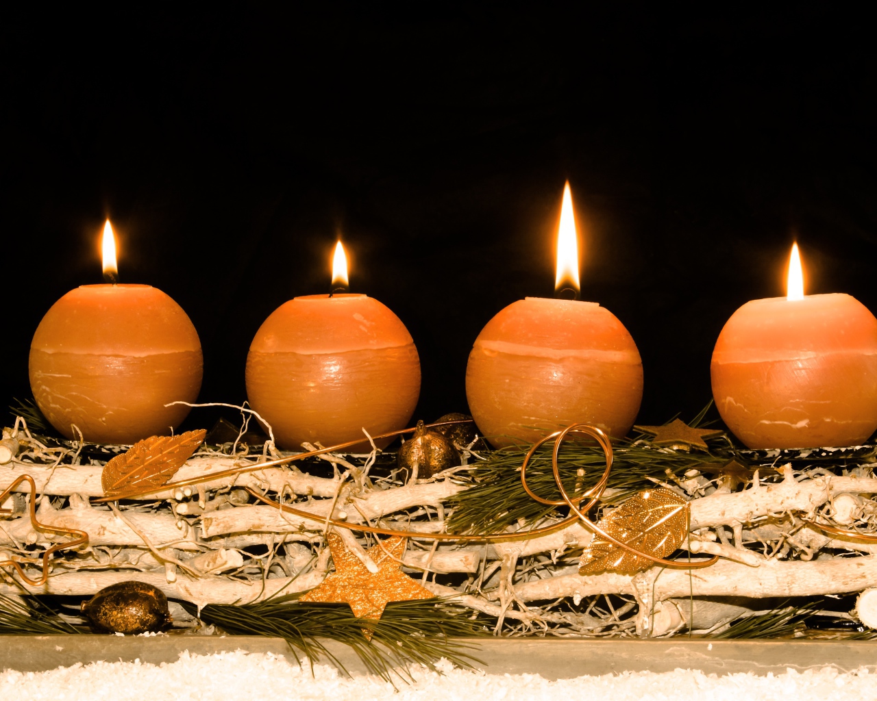 Четыре круглые зажженные свечи на черном фоне