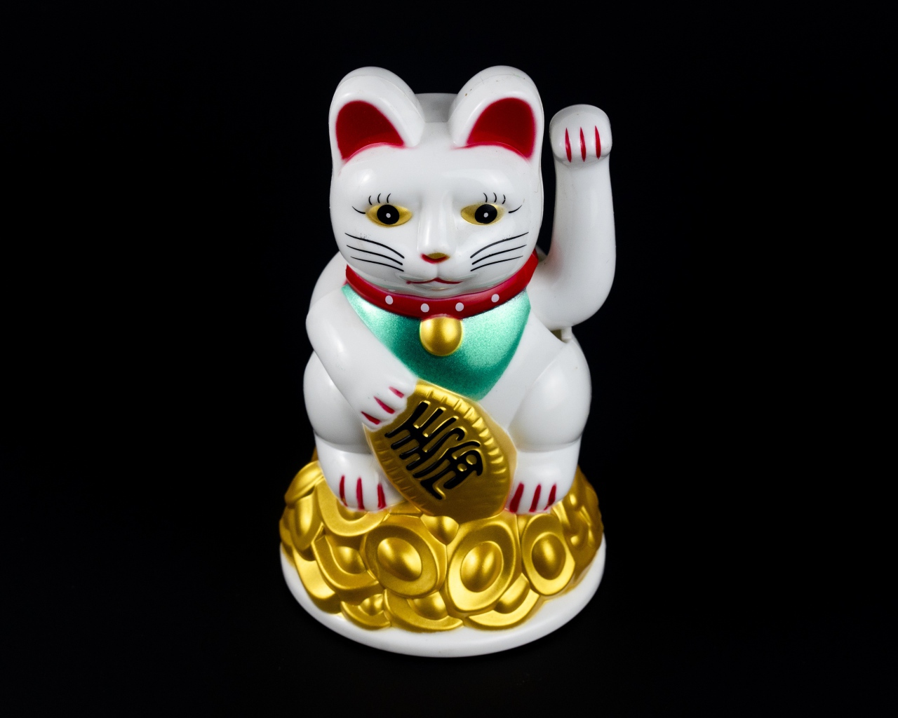Японская фигурка манэки-нэко кошка на черном фоне