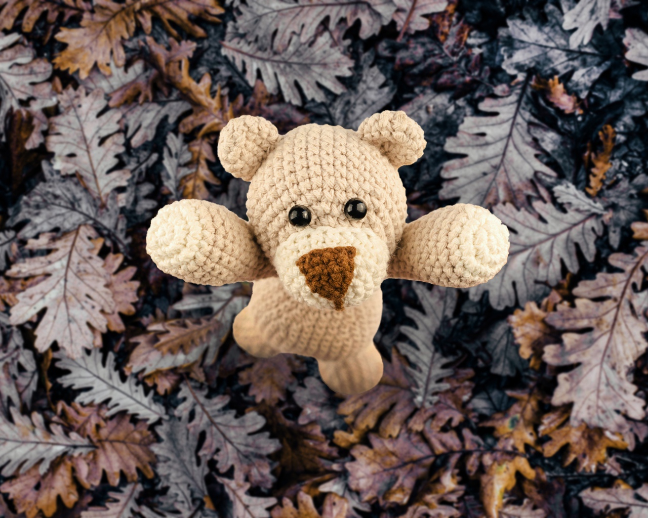Вязаная игрушка медвежонок на листве