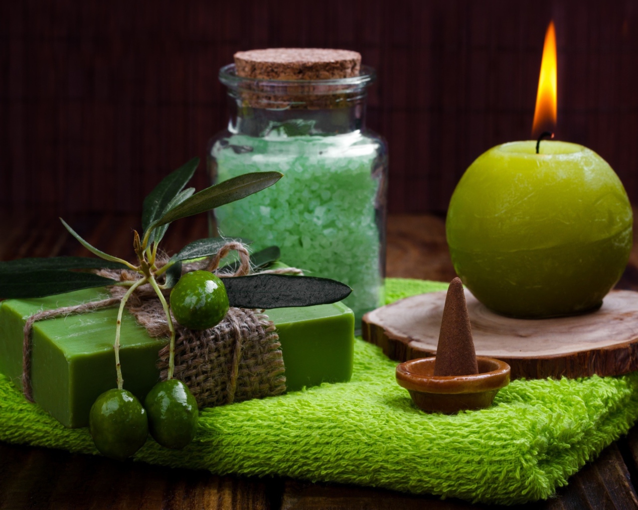 Зажженная свеча и мыло с оливками  и солью 