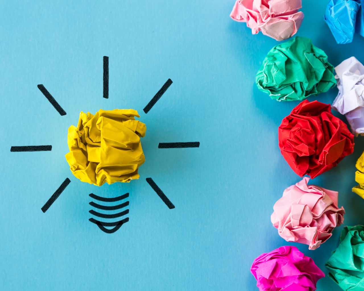 Комки разноцветной бумаги на голубом фоне 