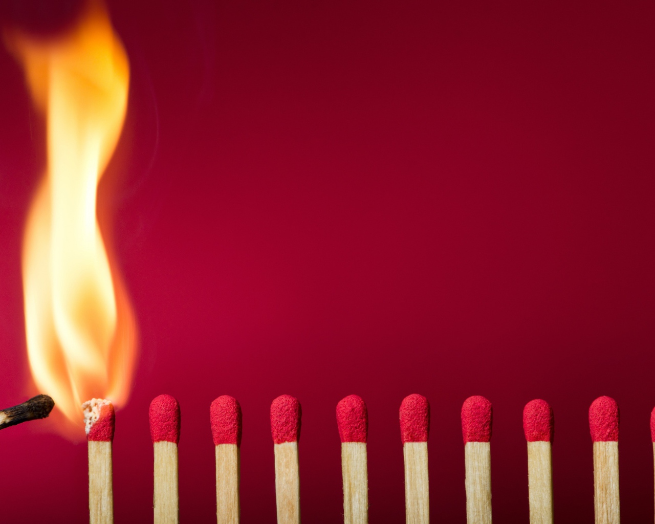 Спички поджигают на красном фоне