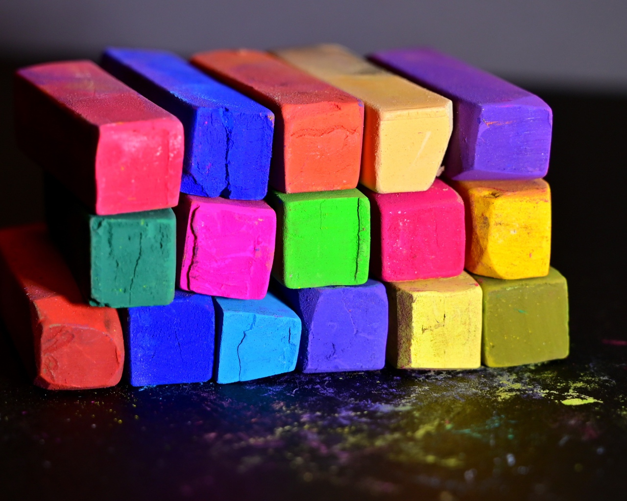 Разноцветные мелки для школы на черной поверхности 