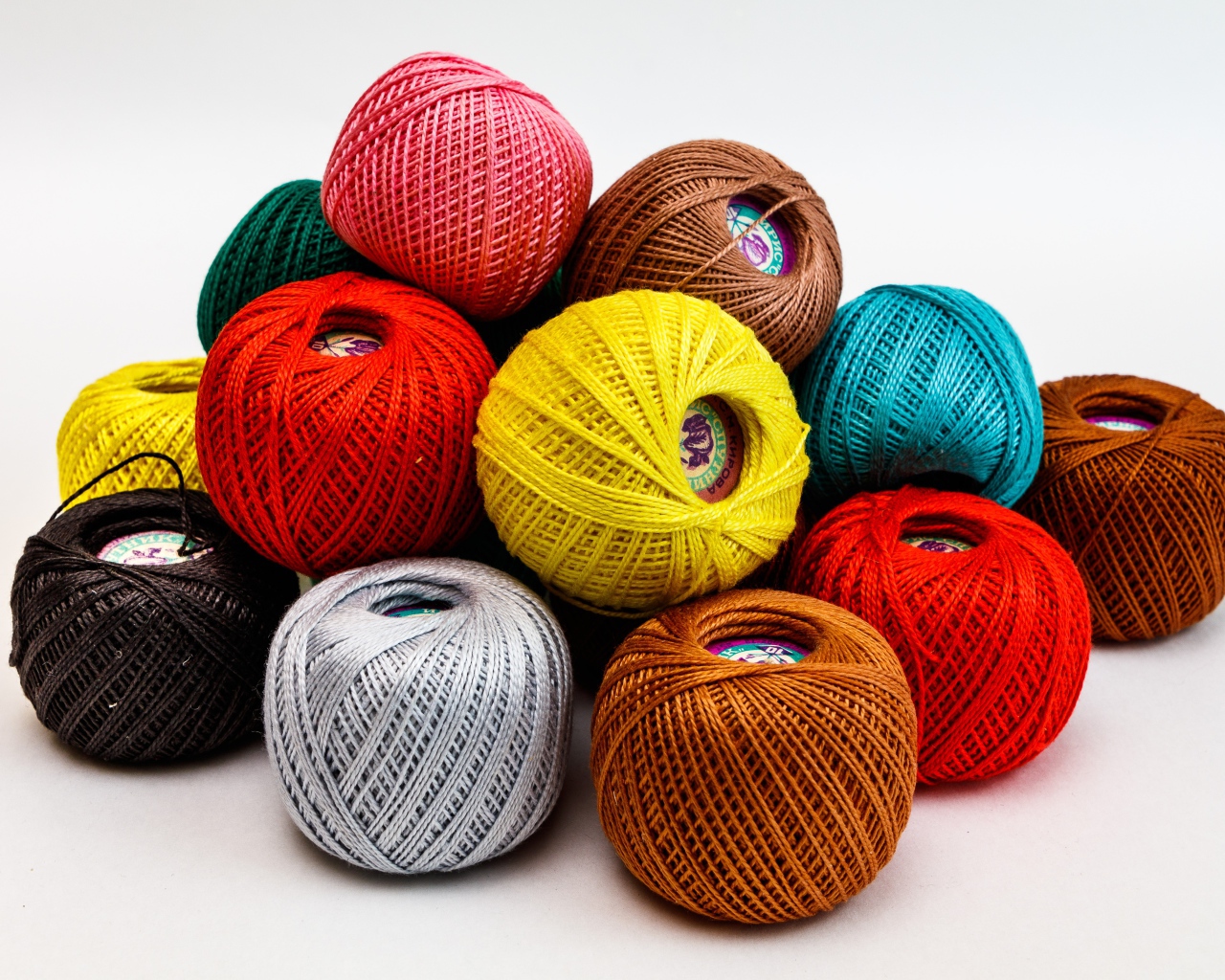 Разноцветные клубки пряжи на белом фоне 