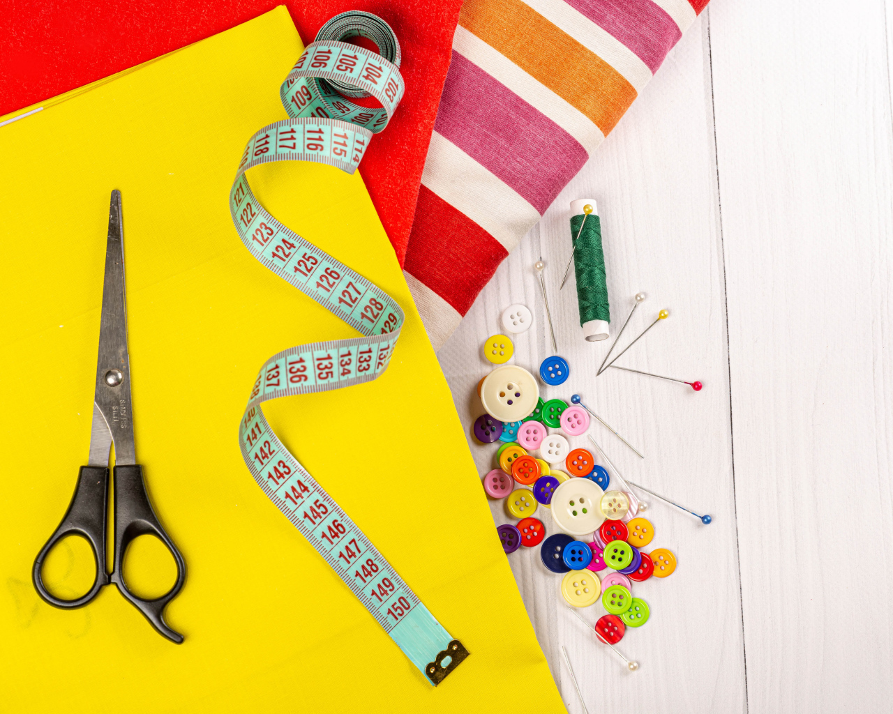 Разноцветная бумага и набор для шитья на столе 