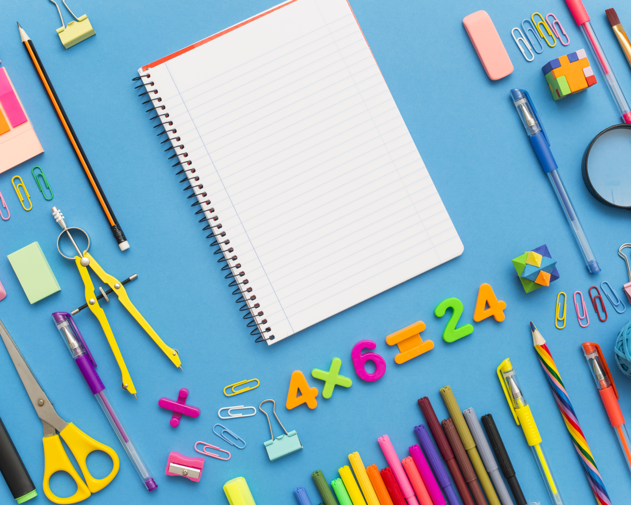 Тетрадь с канцелярскими предметами на голубом фоне 