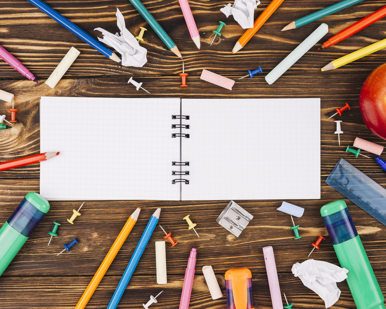 Открытый блокнот с ручками  на столе 