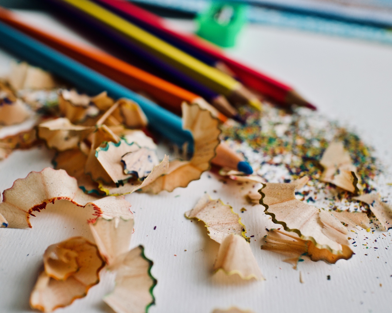 Карандаши со стружкой на сером столе 