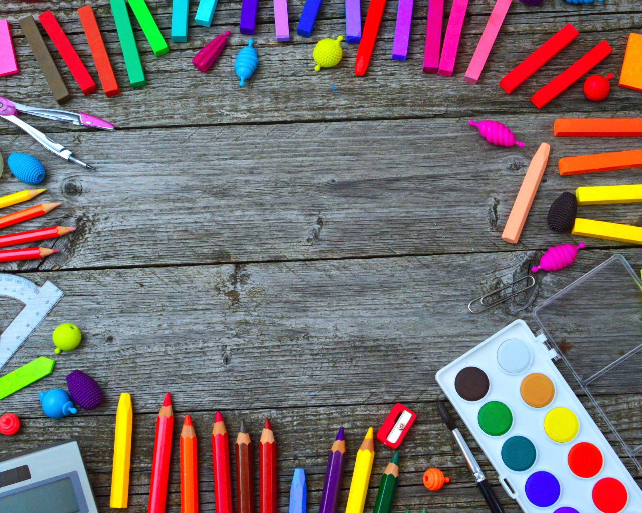 Радуга ярких канцелярских предметов для школы  на деревянном столе