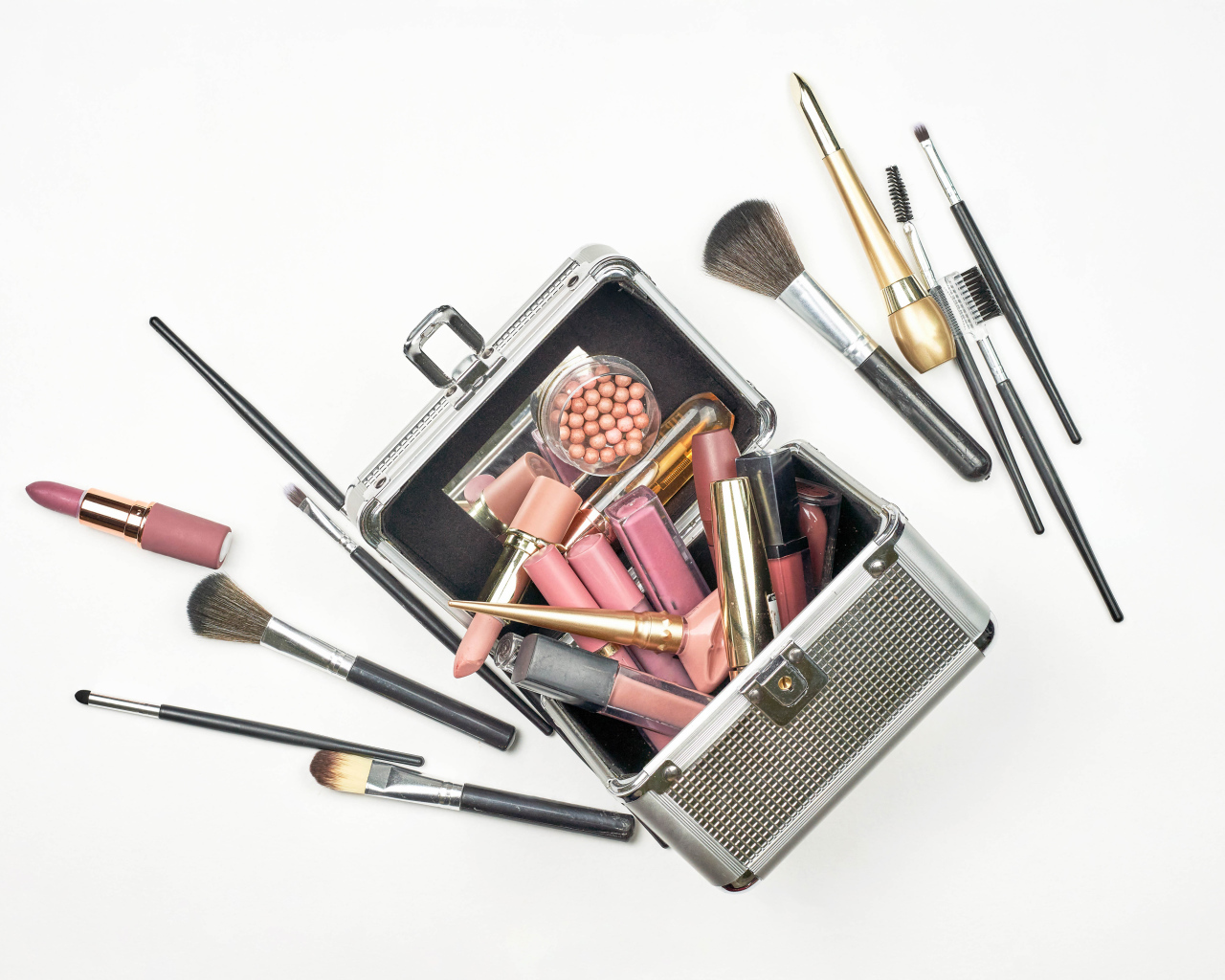 Набор косметики в чемодане на белом фоне