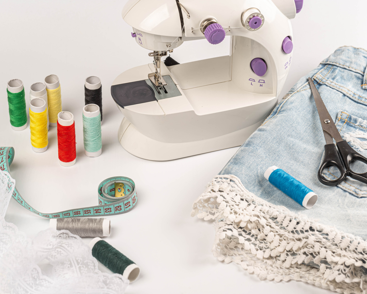 Швейная машинка,юбка и нитки на белом фоне 
