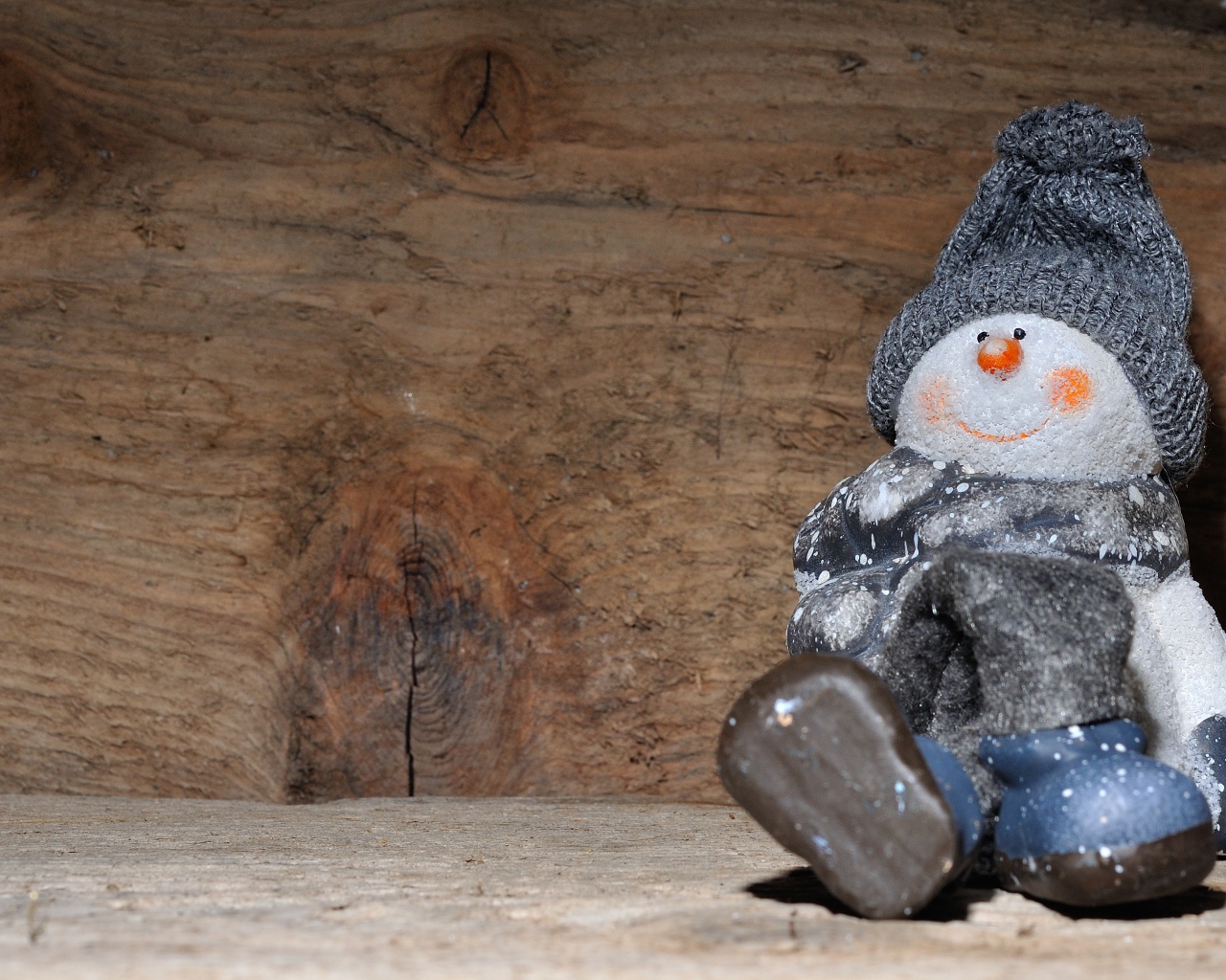 Фигурка снеговик у деревянной стены