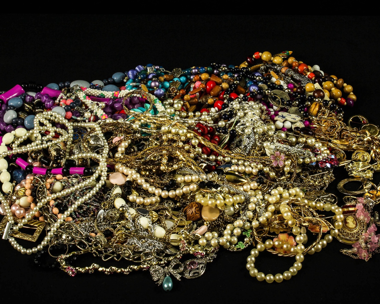 Много драгоценных ювелирных украшений на черном фоне