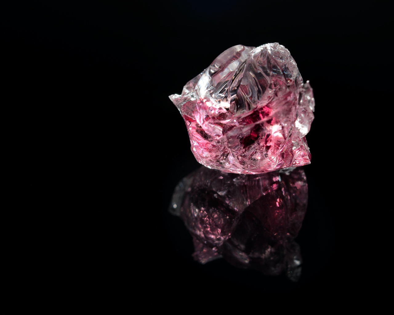 Розовый драгоценный камень на черном фоне 