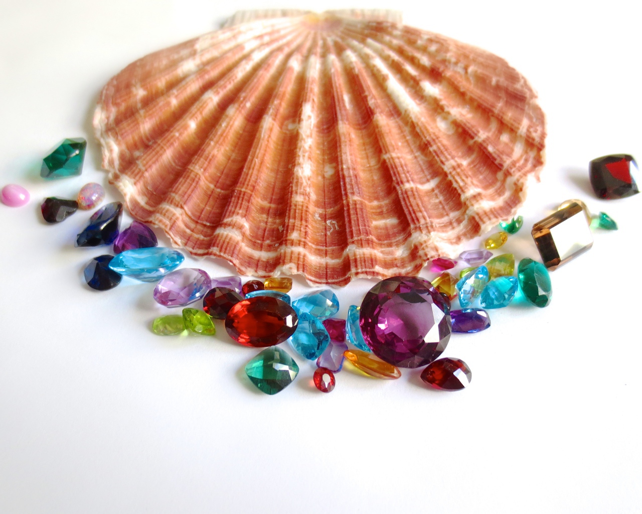 Ракушка и драгоценные камни на белом фоне