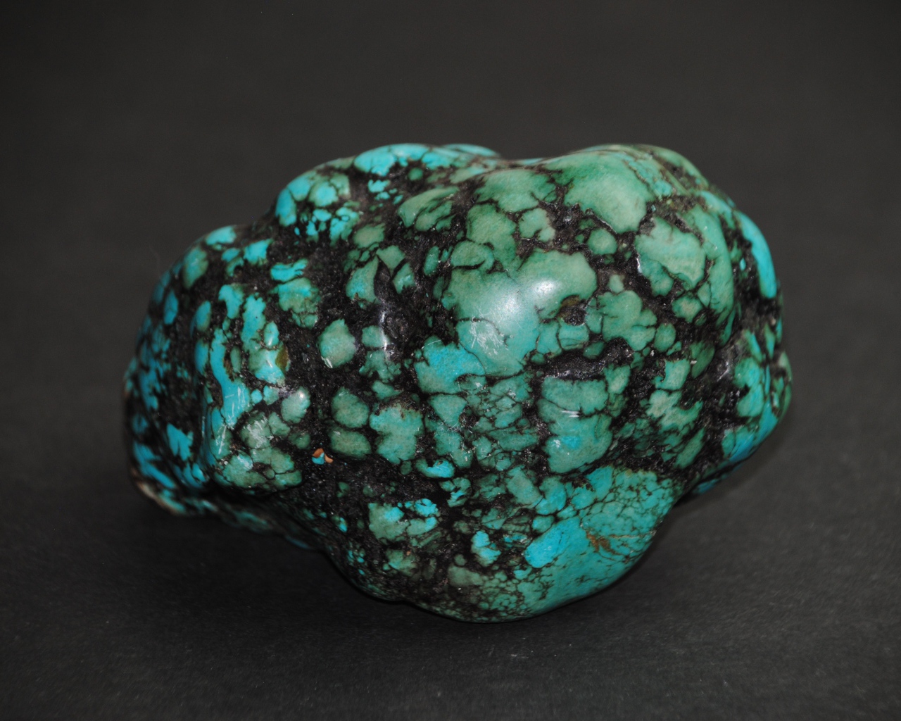 Драгоценный камень бирюзы на сером фоне