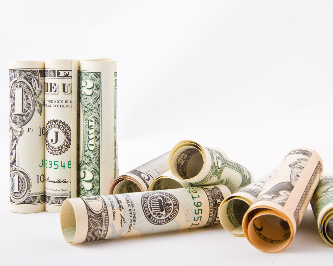 Скрученные в трубочки доллары на белом фоне 