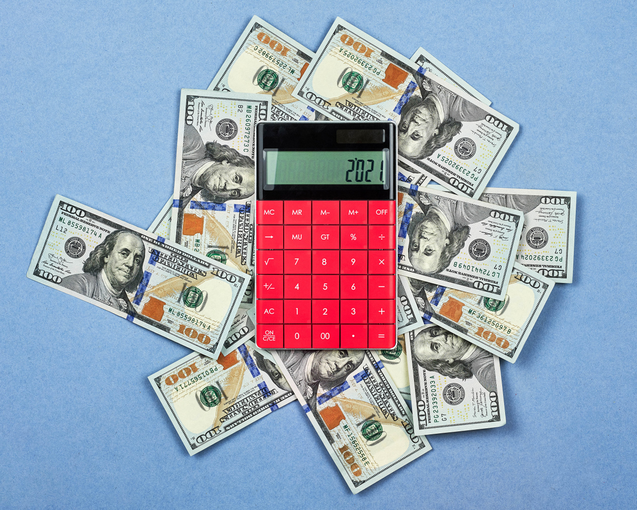 Много долларов с калькулятором на синем фоне