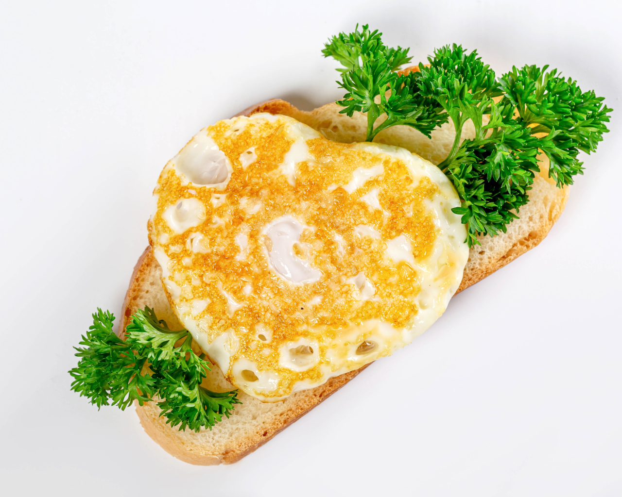 Кусок хлеба с яичницей и петрушкой