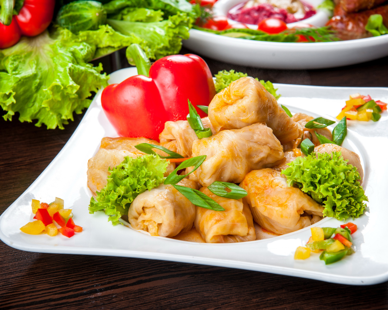 Аппетитные голубцы на тарелке с перцем 