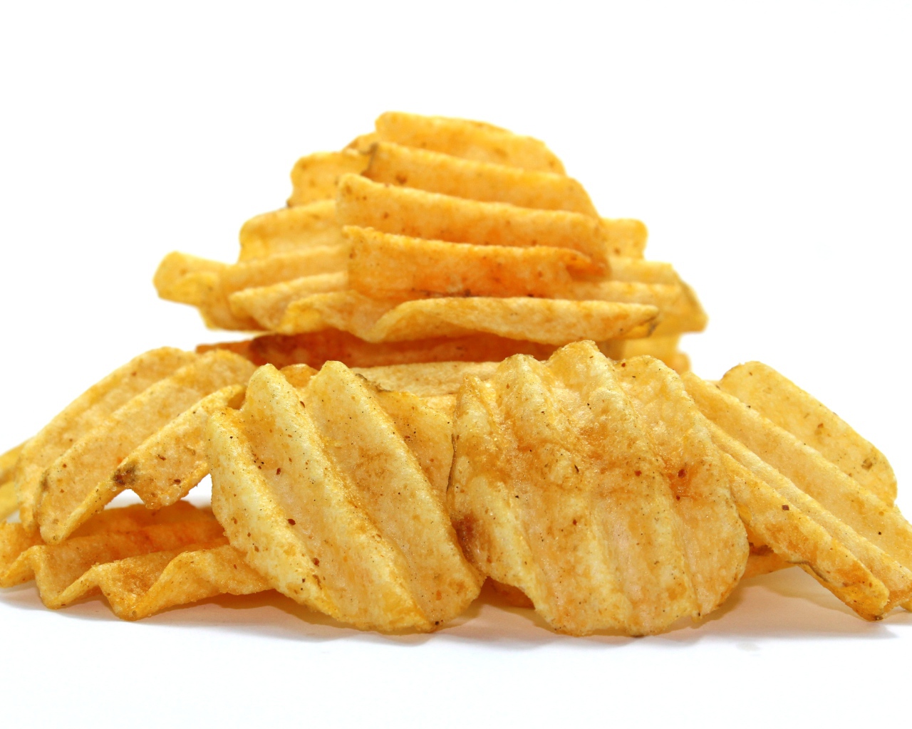 Аппетитные картофельные чипсы на сером фоне