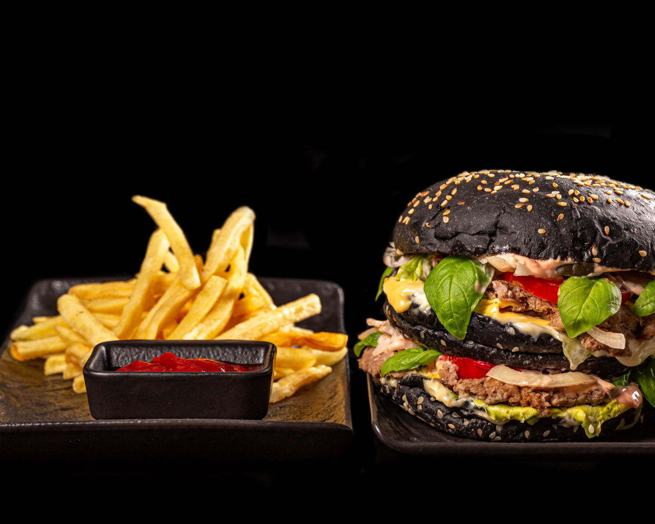 Большой черный гамбургер с картофелем фри и кетчупом 