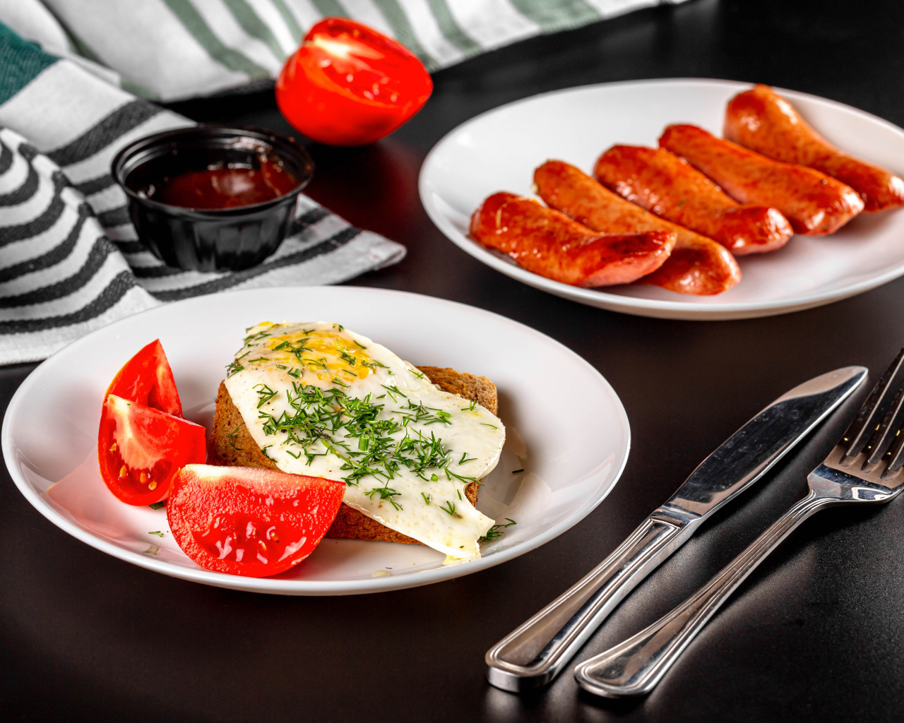 Хлеб с яичницей и помидорами на тарелке с сосисками