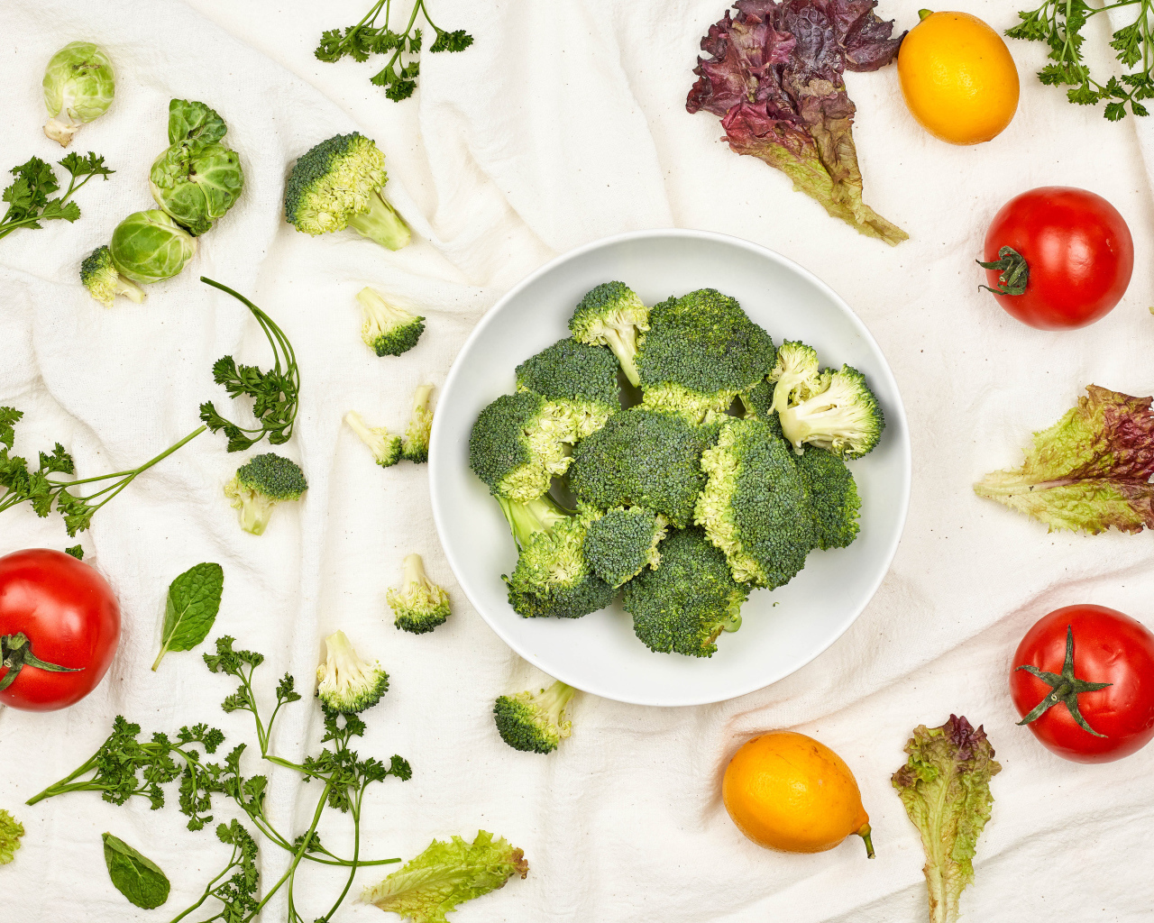 Брокколи на столе с помидорами и зеленью