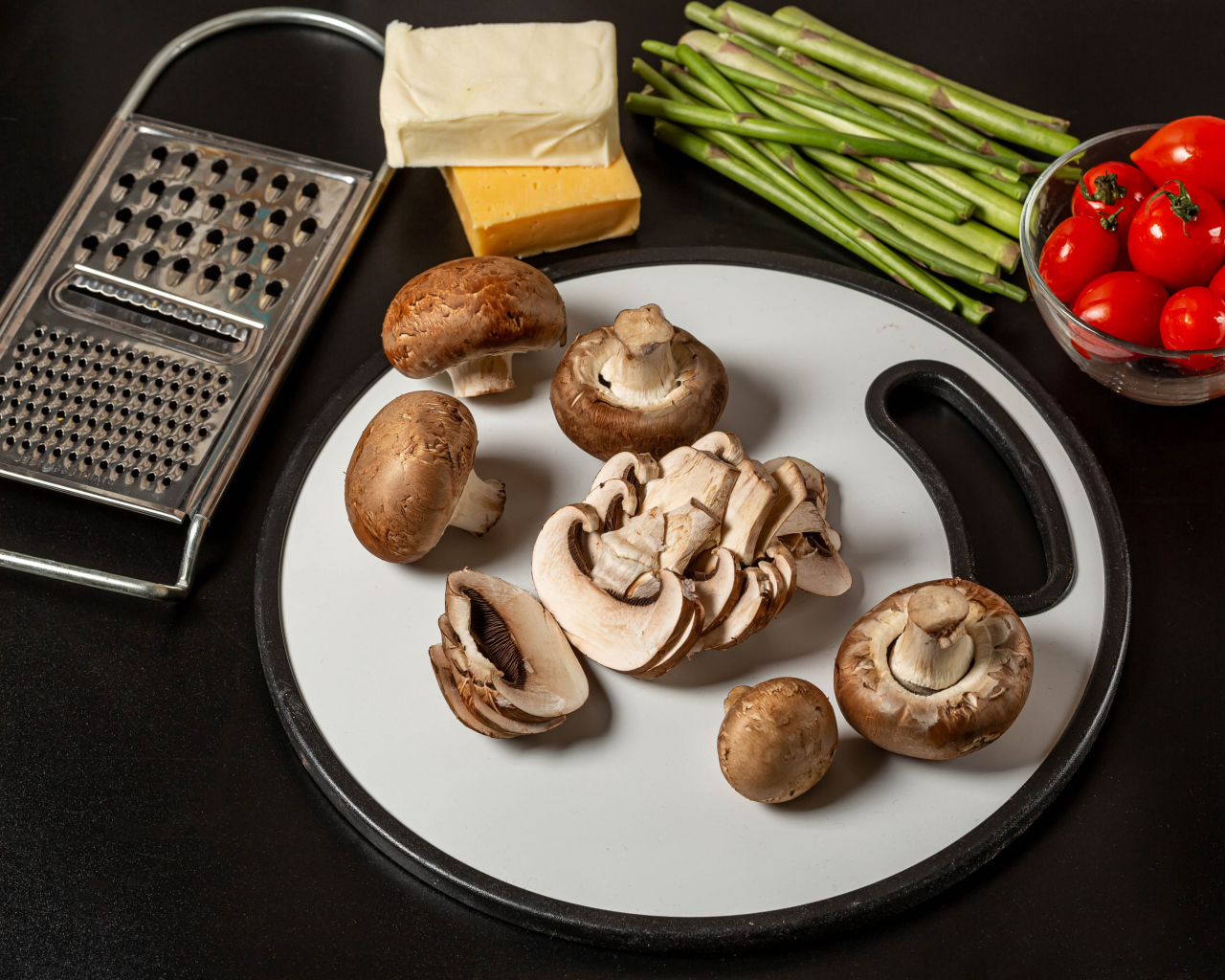 Шампиньоны на столе со спаржей и помидорами 