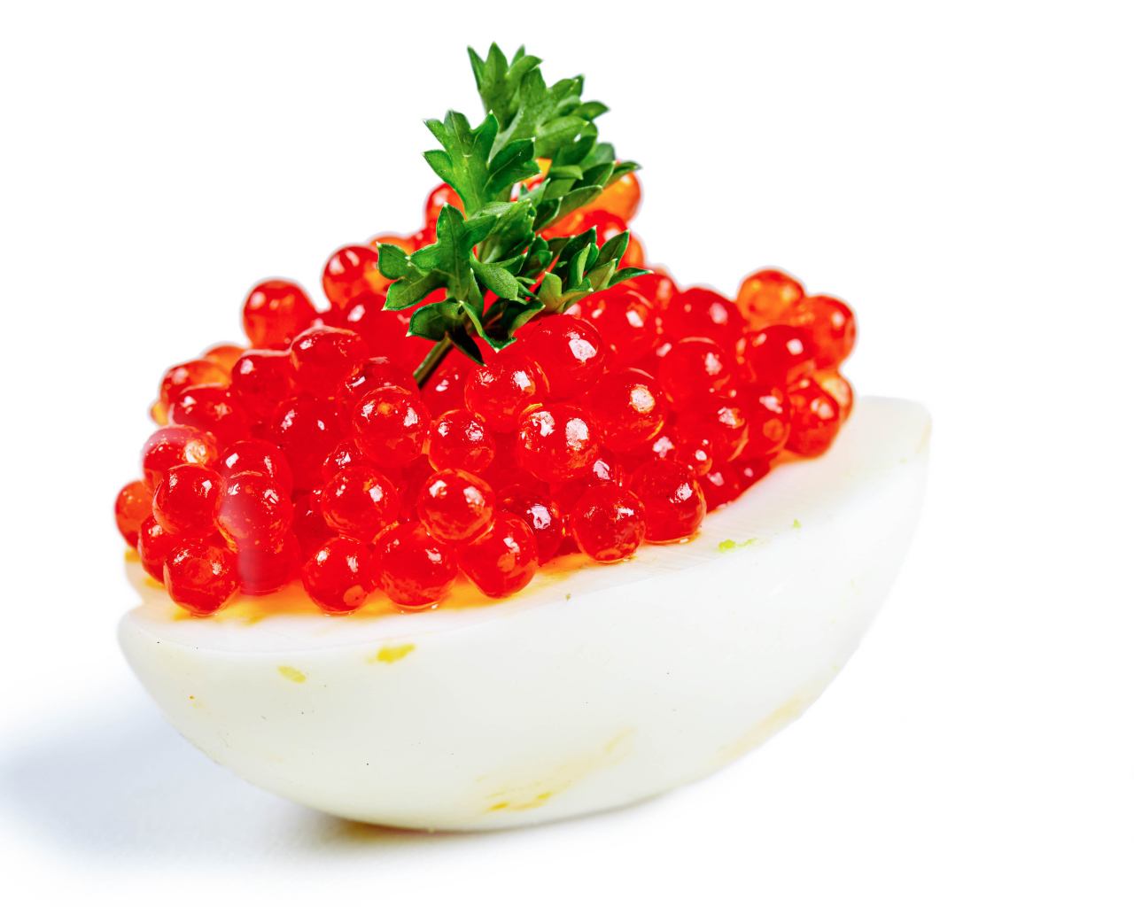 Яйцо фаршированное красной икрой на белом фоне