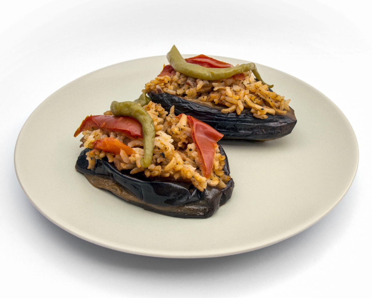 Блюдо из баклажанов с рисом на большой белой тарелке