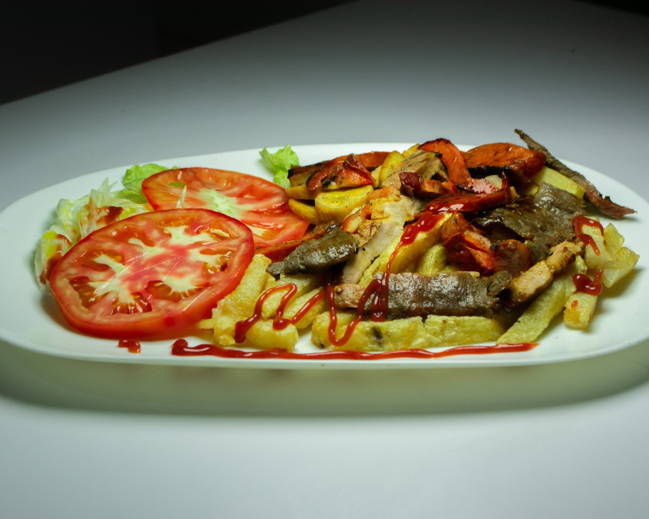 Картофель фри на тарелке с помидорами 