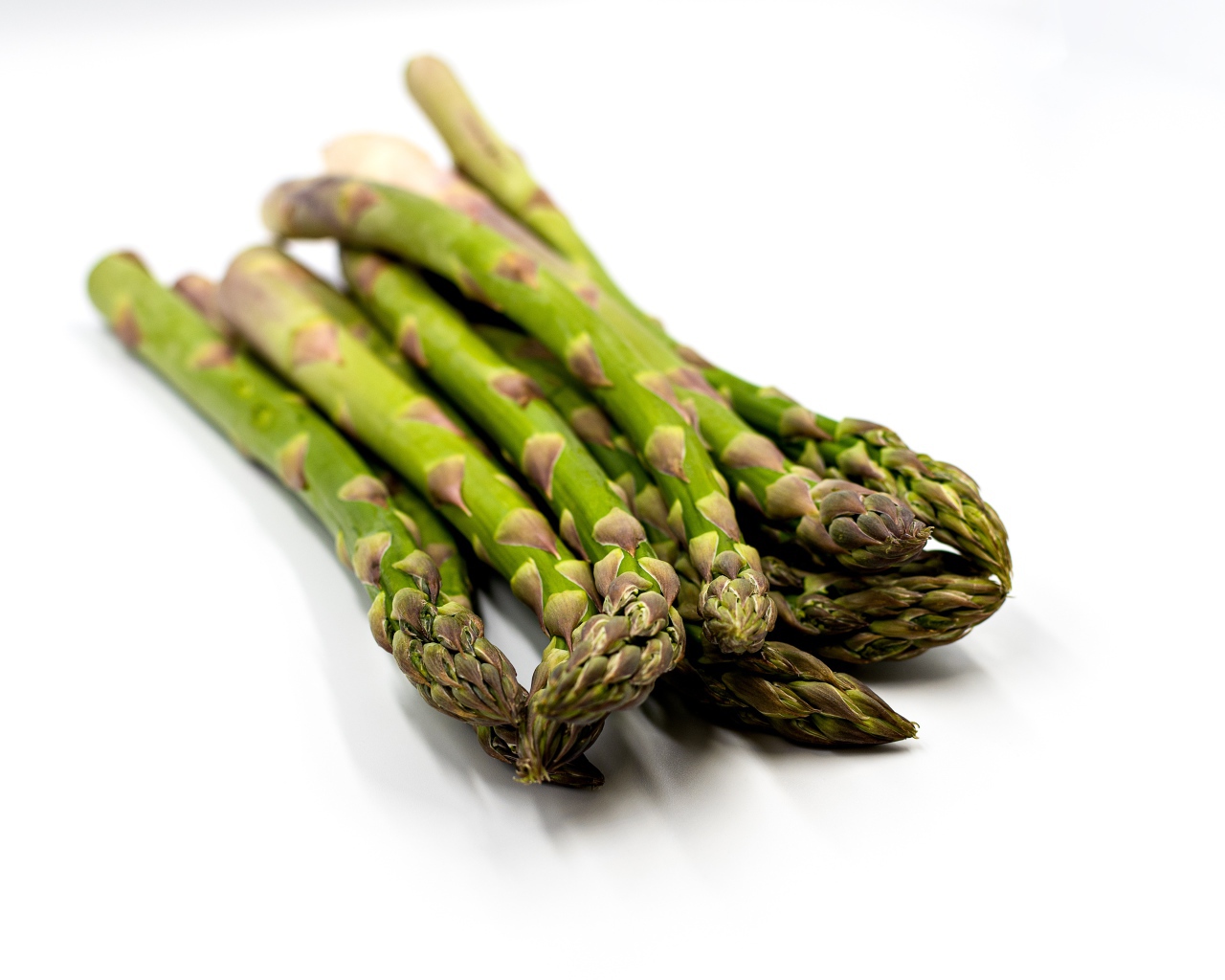 Свежая зеленая спаржа на белом столе