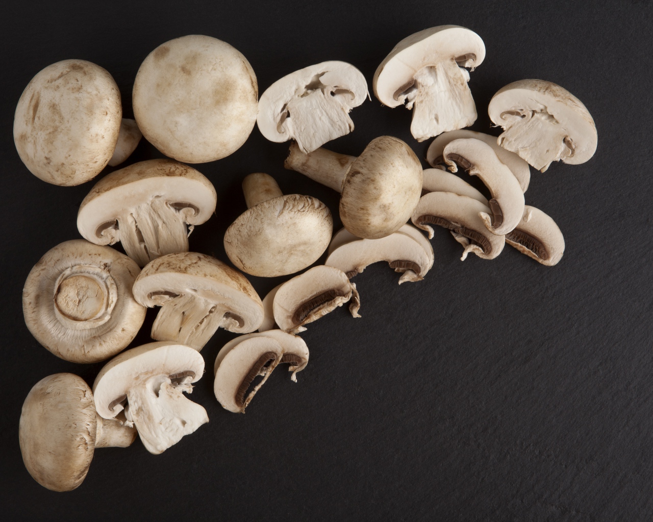 Свежие нарезанные шампиньоны на сером фоне