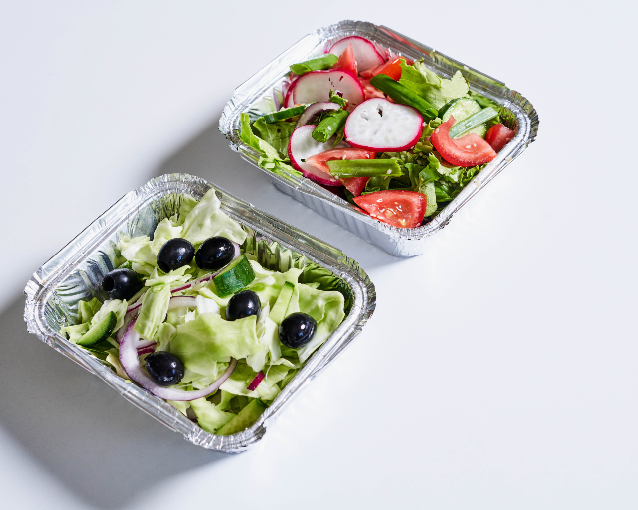 Салат из свежих овощей в тарелках на сером фоне 