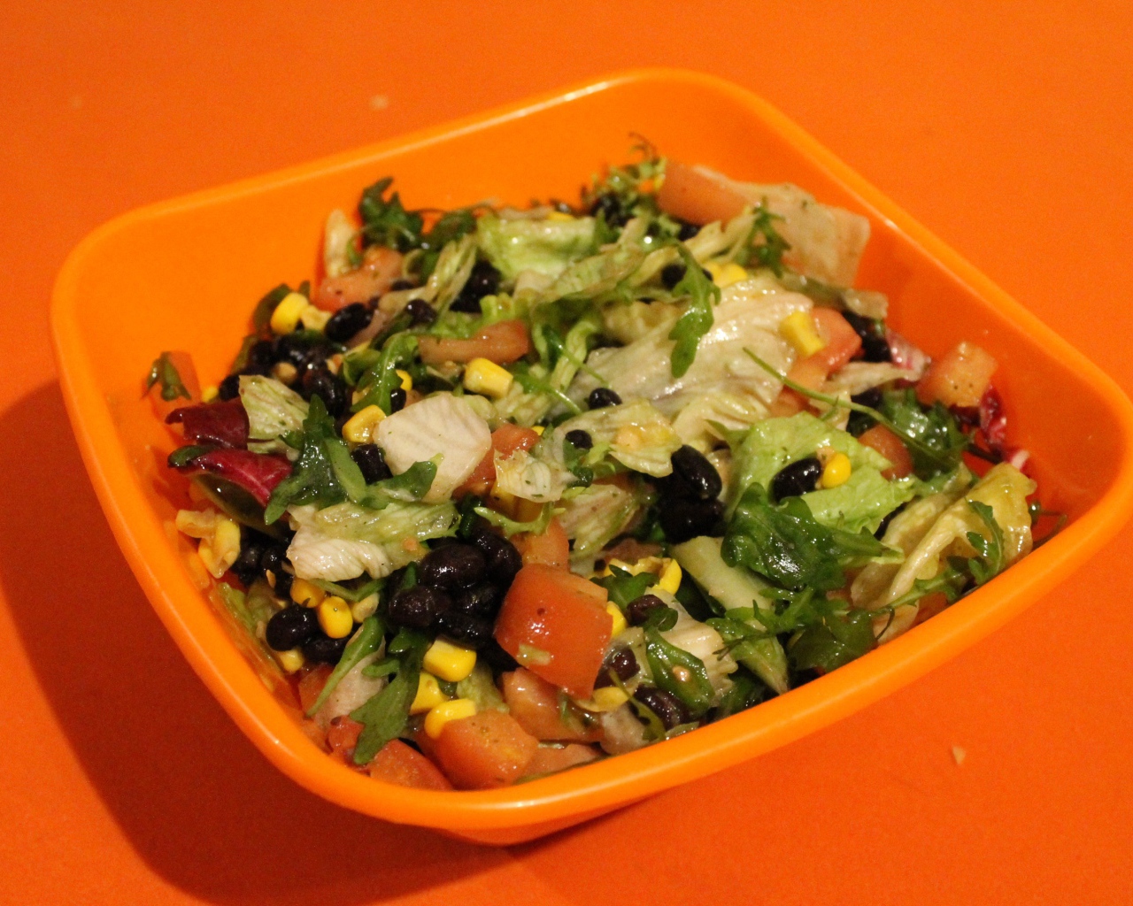 Салат из свежих овощей на оранжевом фоне