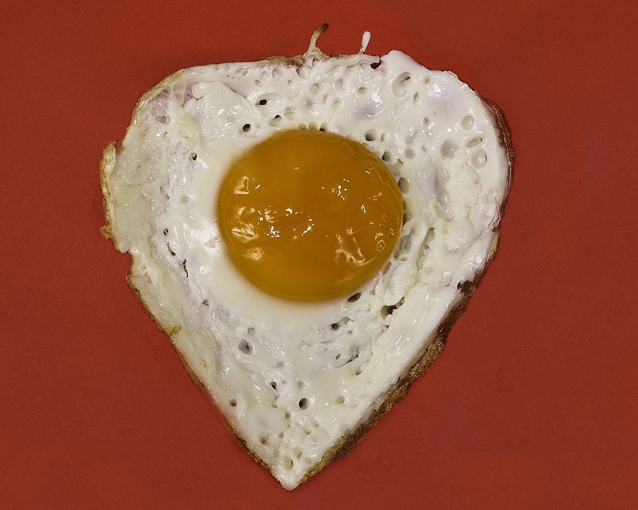 Яичница глазунья на красном фоне